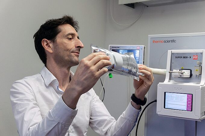 Pablo Sinues schliesst einen Beutel mit einer Atemluftprobe zur Analyse an ein Massenspektrometer an. © Universität Basel, Christian Flierl